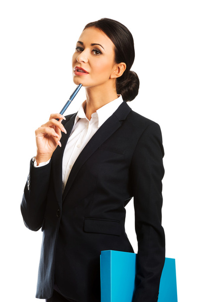 Thoughtful businesswoman holding a pen - 写真・画像