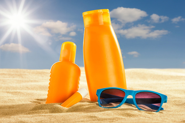 Verschiedene Sonnenschutzmittel im Sand - Foto, Bild