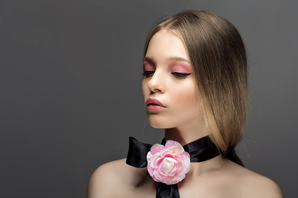 Portrait of young beautiful healthy woman with fancy pink rose o - Фото, зображення