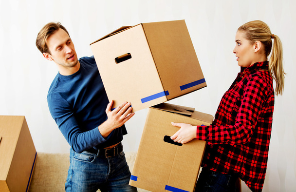 Young couple with boxes - packing or unpacking - Fotó, kép