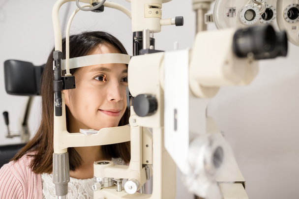 Woman looking in ophthalmoscope - Foto, Imagen