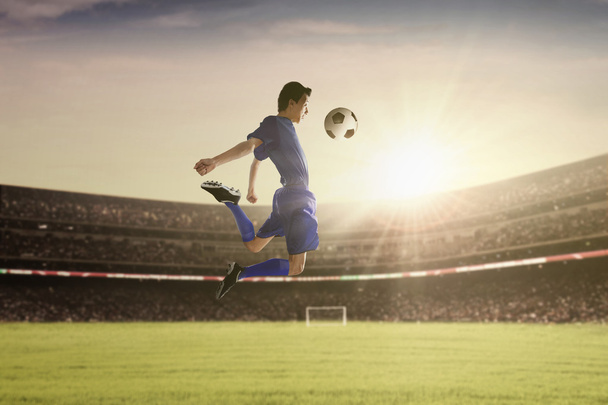 サッカー選手はボールに耐える - 写真・画像
