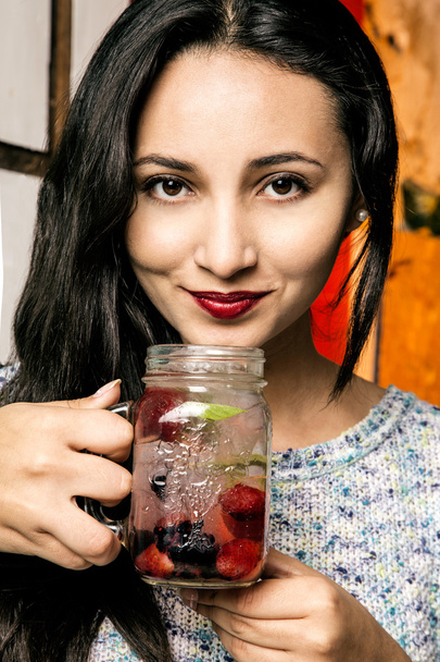 Young woman drinking fruit-infused water - Foto, Bild