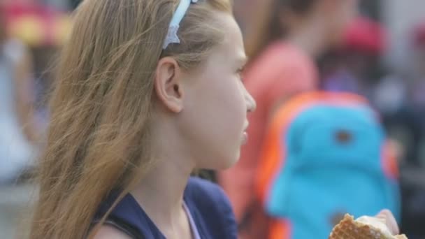kleines Mädchen isst Eis an einem heißen, schwülen Sommertag auf dem Spielplatz im Park, Kinder - Filmmaterial, Video