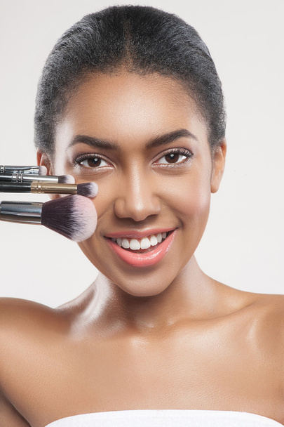 Happy young african woman with cosmetic tools - Foto, Bild