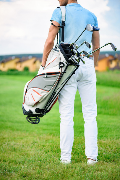 Young golfer holding golf bag - Фото, зображення