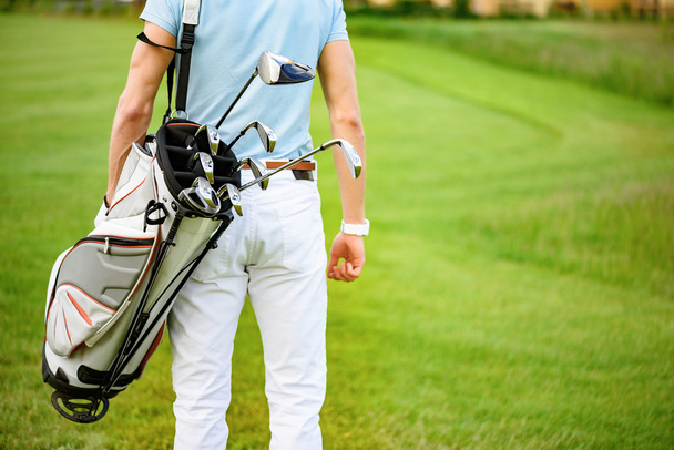 Golfer walking with golf bags - Foto, imagen
