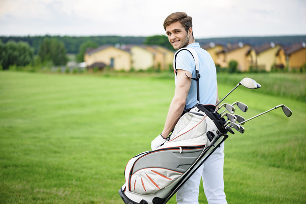 Golfer walking with golf bags - 写真・画像