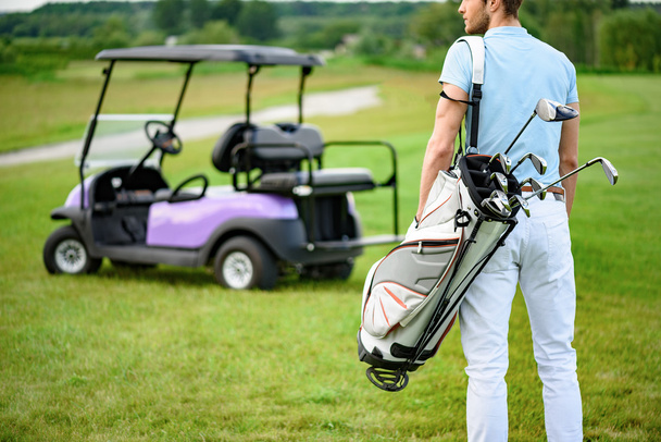 Golfer walking with golf bags - Фото, изображение