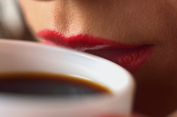 Girl in a white men's shirt drinking coffee from a white cup. Close-up of lips. Macro with blur and soft focus. - Фото, изображение