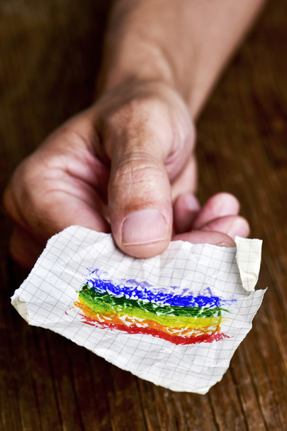 Mann mit einem Stück Papier mit einer Regenbogenfahne - Foto, Bild