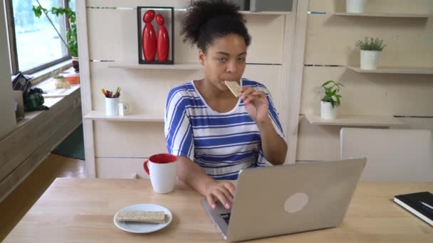 Woman eating healthy snack and working on the computer. - Video, Çekim
