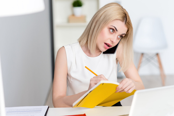 Attractive blond woman is working in office - 写真・画像