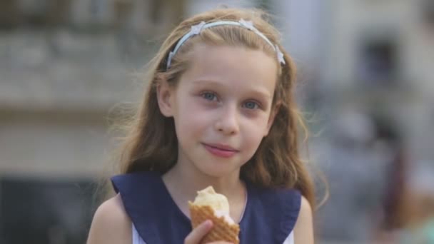 Mała dziewczynka jedzenie lodów w Hot, upalny letni dzień na placu zabaw w parku, dzieci - Materiał filmowy, wideo