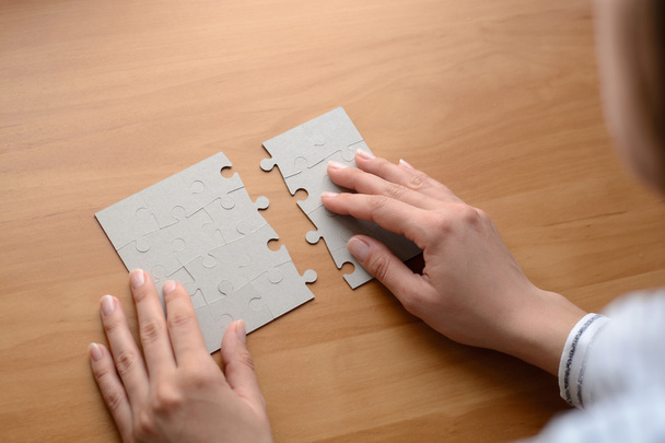 Ženské ruce na dřevěný kancelářský stůl vybrat puzzle - Fotografie, Obrázek