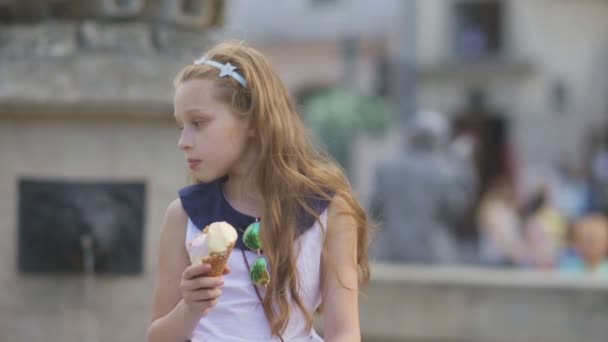 Κοριτσάκι που τρώει παγωτό σε ένα ζεστό, καυτηρός καλοκαιρινή μέρα στην παιδική χαρά στο πάρκο, τα παιδιά - Πλάνα, βίντεο