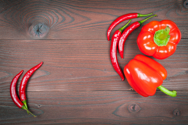 Red paprika with chilli peppers on wooden background - Foto, imagen