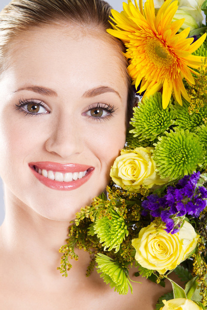 Attractive young woman portrait with flowers - 写真・画像
