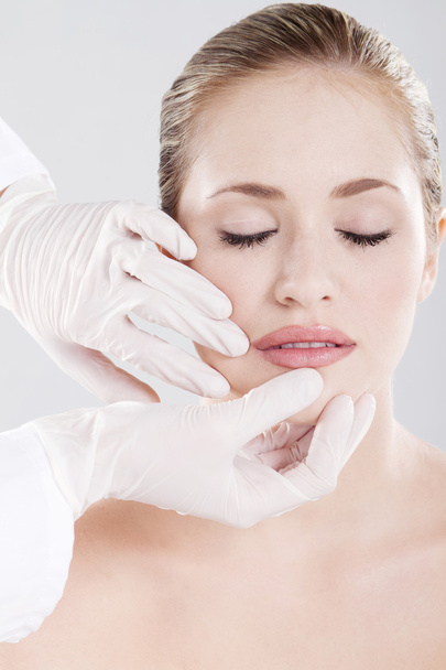 Doctor checking woman's lips before cosmetic surgery - Valokuva, kuva
