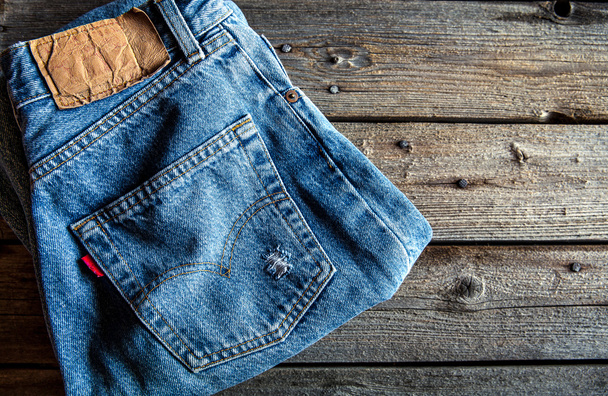 Neatly folded jeans on wooden background. Clothing, fashion, sty - Photo, Image