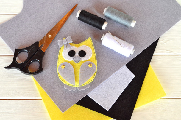 Felt owl toy. Children's crafts idea project. Homemade Christmas ornaments for kids diy. Felt sheets, scissors, thread, needle, pins - a set for needlework. Wooden background. - Valokuva, kuva