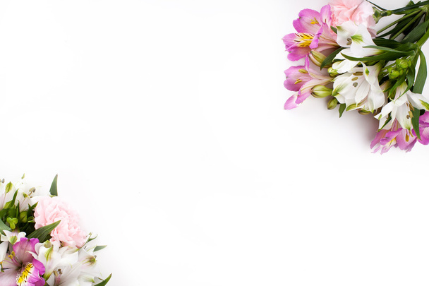 Рожеві та фіолетові квіти з альстромеріями на білому фоні
 - Фото, зображення