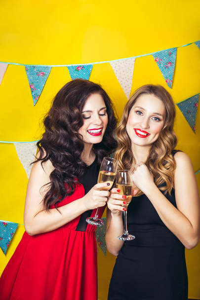 Portrait of joyful friends toasting and looking at camera at birthday party. Attractive friends celebrating a birthday. Smiling girls with glasses of champagne - Φωτογραφία, εικόνα