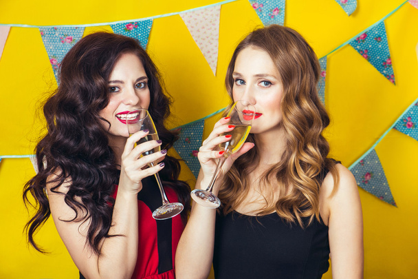 Portrait of joyful friends toasting and looking at camera at birthday party. Attractive friends celebrating a birthday. Smiling girls with glasses of champagne - Foto, Imagem