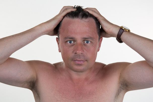 Muotokuva miehestä, joka kampaa hiuksiaan käsillä
 - Valokuva, kuva