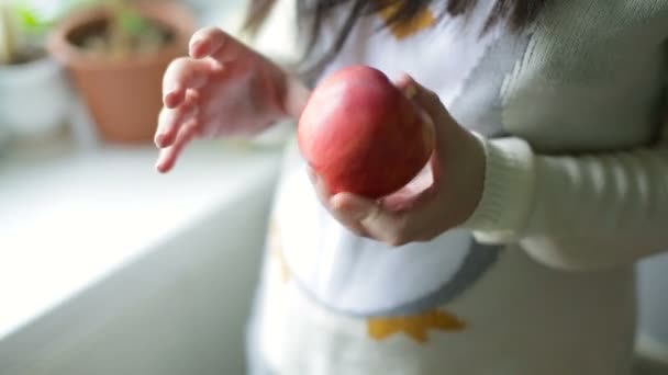 Ripe red apple in the hands of a young girl. - Séquence, vidéo