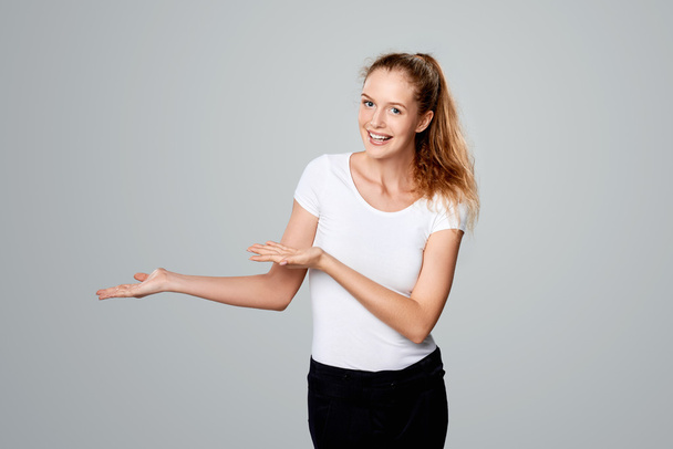 Smiling woman showing open hand palm with copy space - Foto, Bild