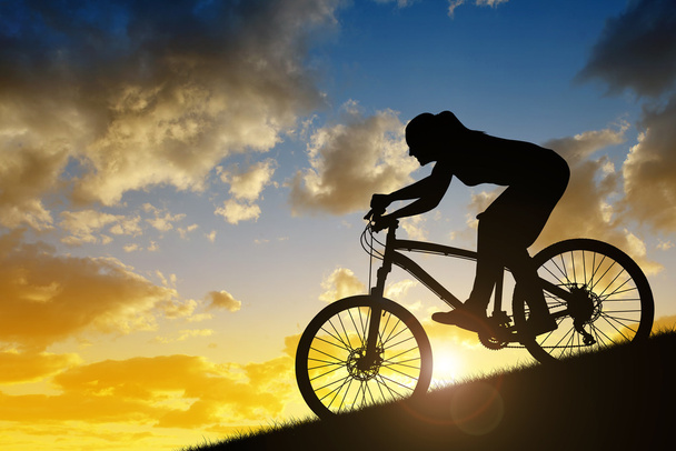 Sziluettje egy lány, lovaglás, mountain bike - Fotó, kép
