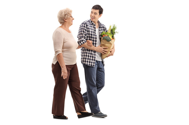 Man helping a senior lady with groceries  - Fotó, kép