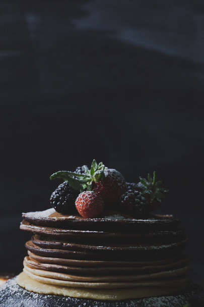 Rustic summer breakfast with chocolate pancakes, strawberries, b - Photo, image