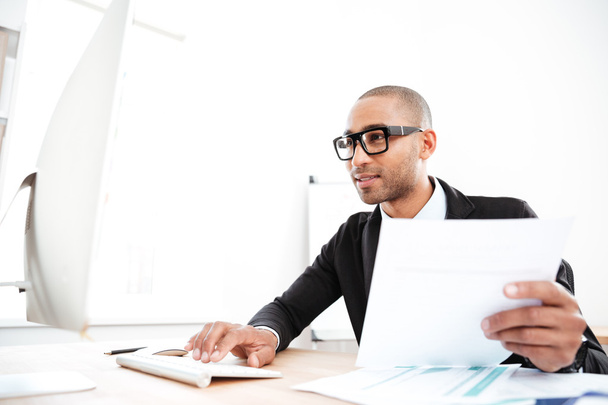 Handsome young businessman working with documents in office - Foto, Bild