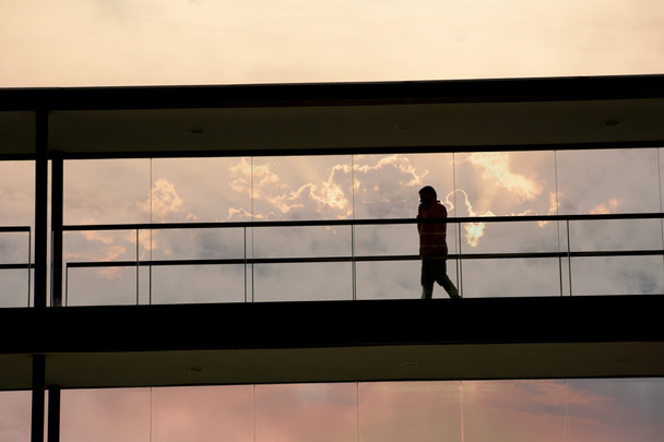 Vista de la silueta del joven empresario en un moderno edificio de oficinas interior
 - Foto, Imagen