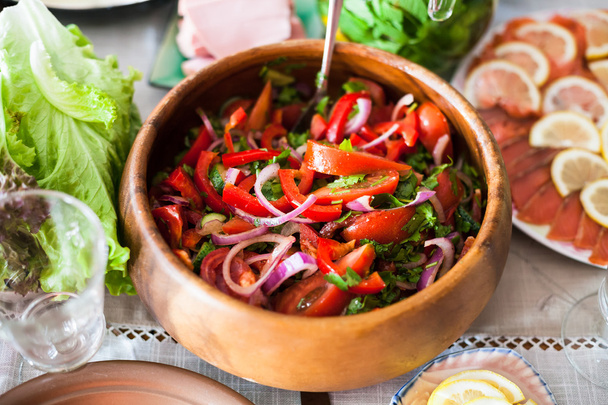 Salade van tomaten, komkommers op tafel geserveerd - Foto, afbeelding