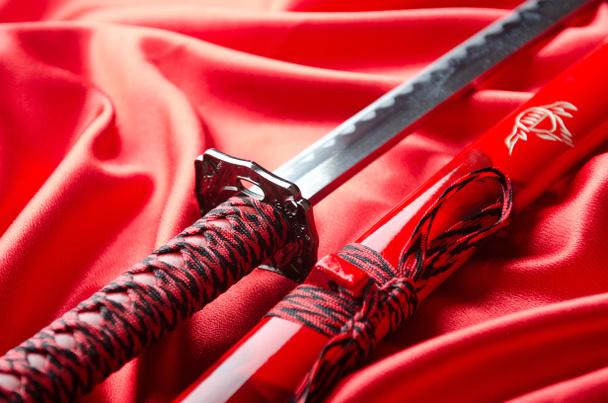 Japanese sword takana on red satin background - Φωτογραφία, εικόνα