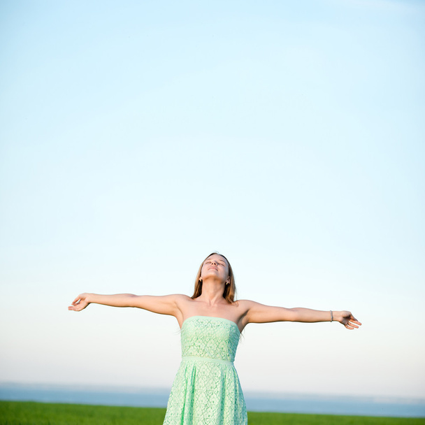 Счастье женщина оставаться на открытом воздухе под солнечным светом заката
 - Фото, изображение