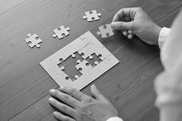 Image of businesswoman connecting elements of white puzzle - Foto, Imagem