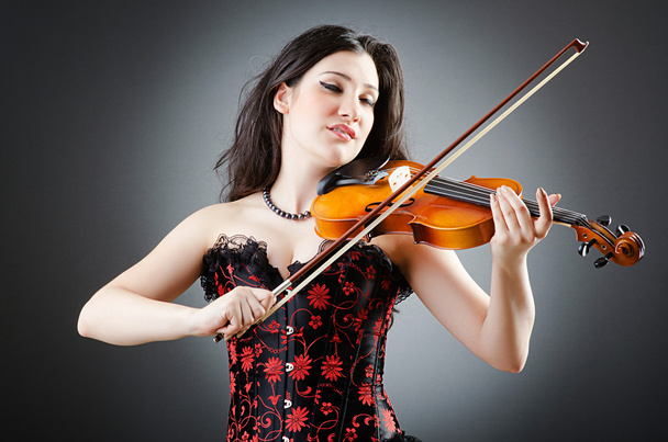 Female violin player against background - Foto, afbeelding