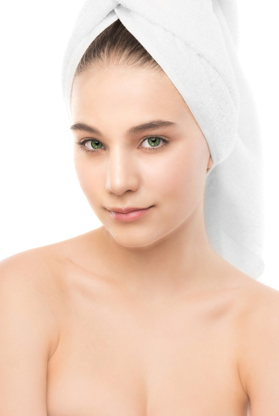 Piękna młoda kobieta brunetka z czystą twarz i ręcznik na głowie. Na białym tle. - Zdjęcie, obraz