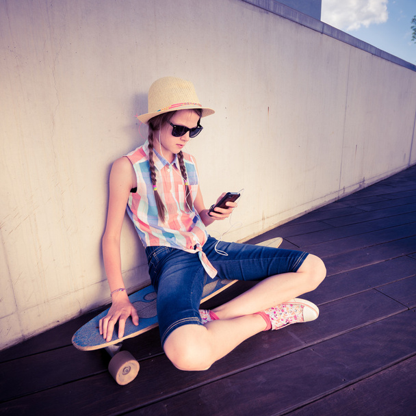Hipster meisje Skateboarder luisteren naar de muziek - ontspannen levensstijl Concept  - Foto, afbeelding