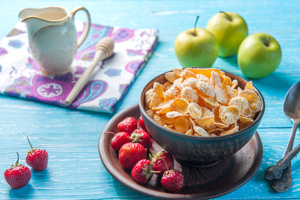Cornflakes in a bowl with milk and fruits on the table - Photo, Image