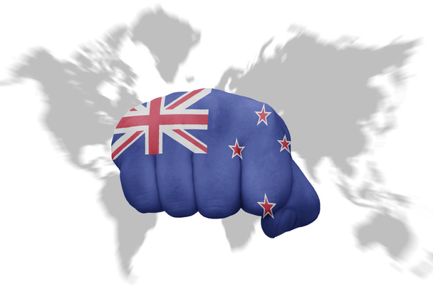nyrkki Uuden-Seelannin lipulla maailmankartalla taustalla
 - Valokuva, kuva
