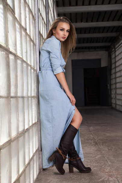Portrait of beautiful woman in denim dress and boots - Photo, image