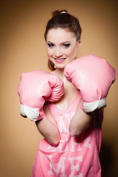 Female boxer wearing big fun pink gloves playing sports - Foto, Imagem