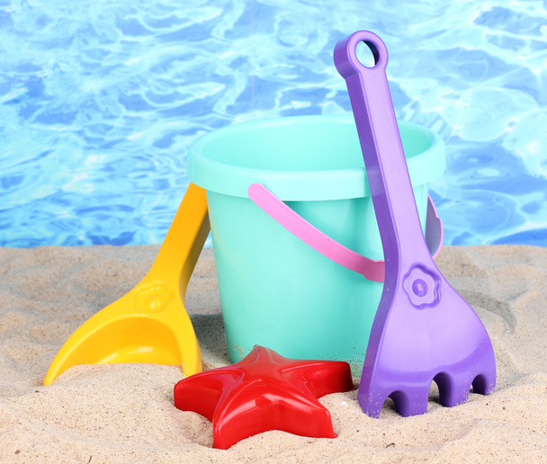 Children's beach toys on sand on water background - Фото, изображение