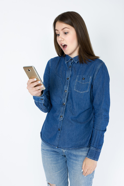 Joven mujer de pelo castaño claro usando un teléfono celular
 - Foto, Imagen