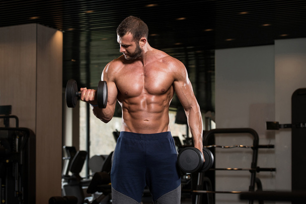 Muscular Man Exercising Biceps With Dumbbells - Photo, image
